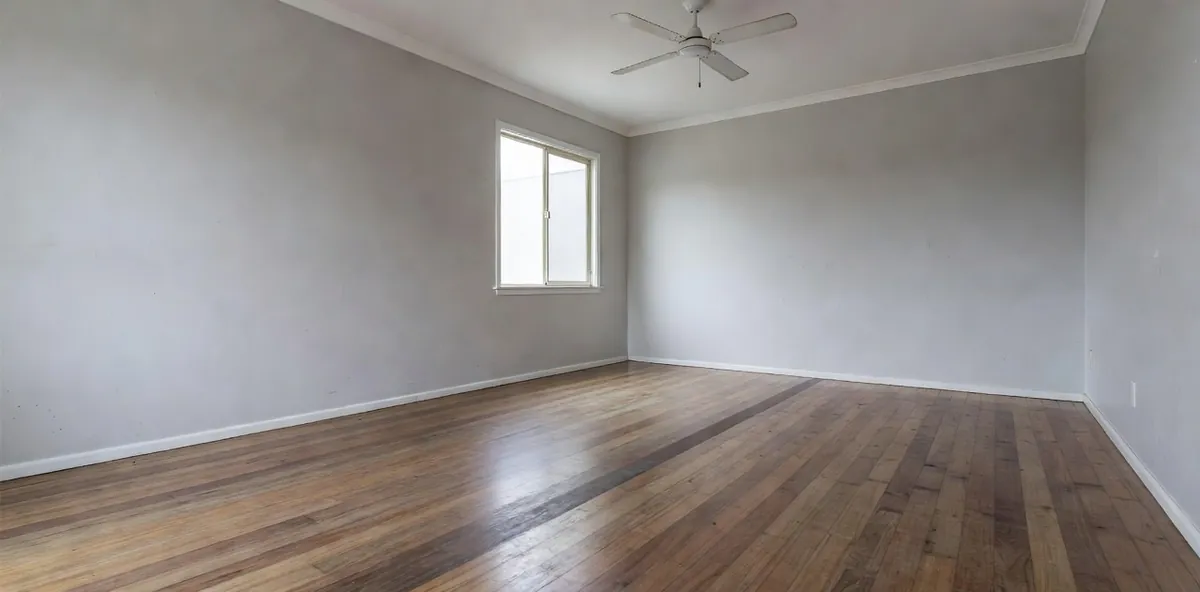 A family room floor with a dull worn traffic lane running across an otherwise sound finish